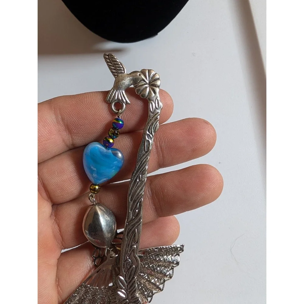 metal hook bookmark with a beaded charm featuring a fan pendant and a blue heart